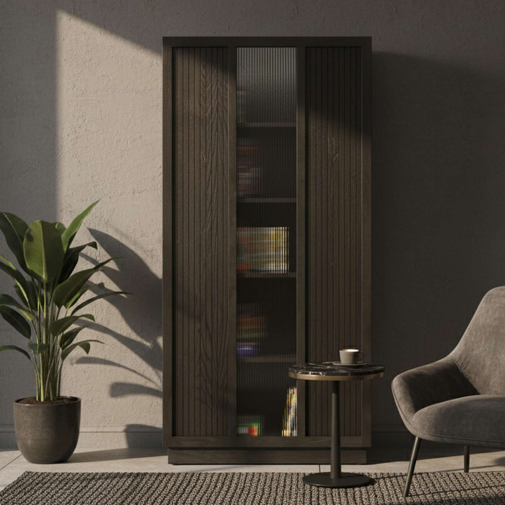 Modern living room scene featuring a tall cabinet, a small table with a cup, a cozy chair, and a potted plant.