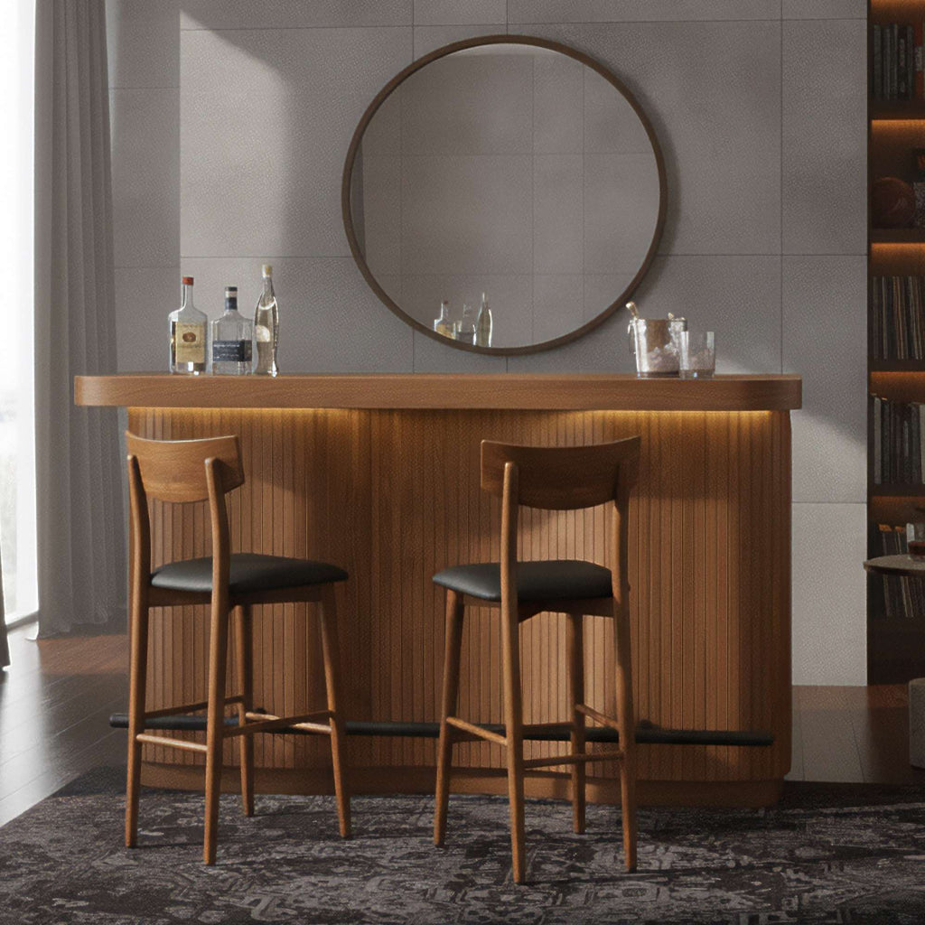 Modern home bar with wooden countertop, two high stools, and a circular mirror.