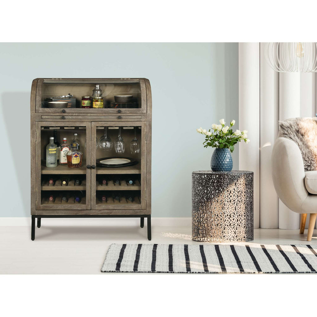 A stylish wooden cabinet with glass doors displaying bottles and glasses, alongside a decorative side table and a cozy chair in a modern living room setting.