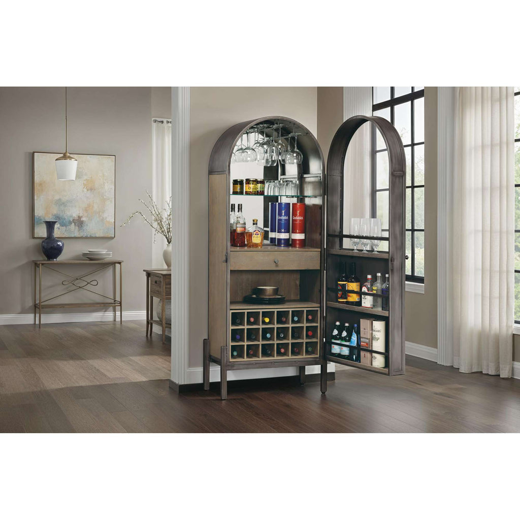 A stylish bar cabinet with rounded doors, showcasing various bottles and storage compartments, set in a modern living space.