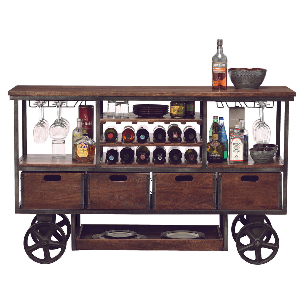 A rustic wooden bar cart with wine bottles, glassware, and storage drawers on wheels.