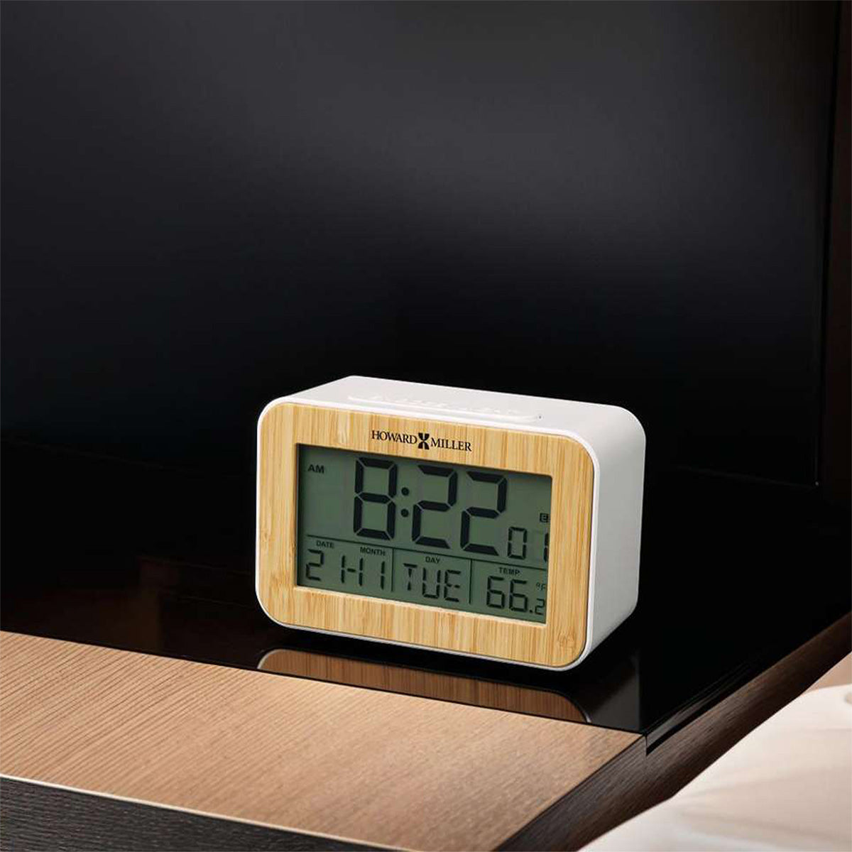 Bamboo alarm clock sitting on a night stand