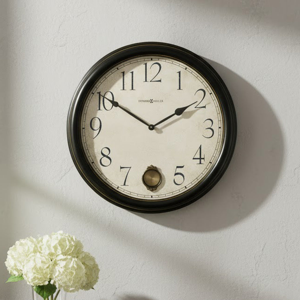 Vintage-style wall clock with black frame, white face, and elegant hour/minute hands.
