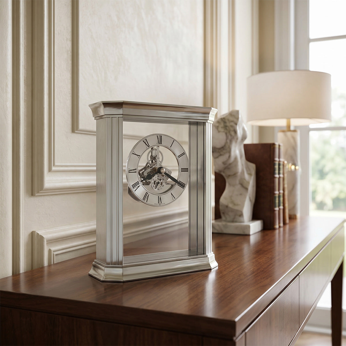 Decorative clock on a wooden surface with a lamp and books in the background