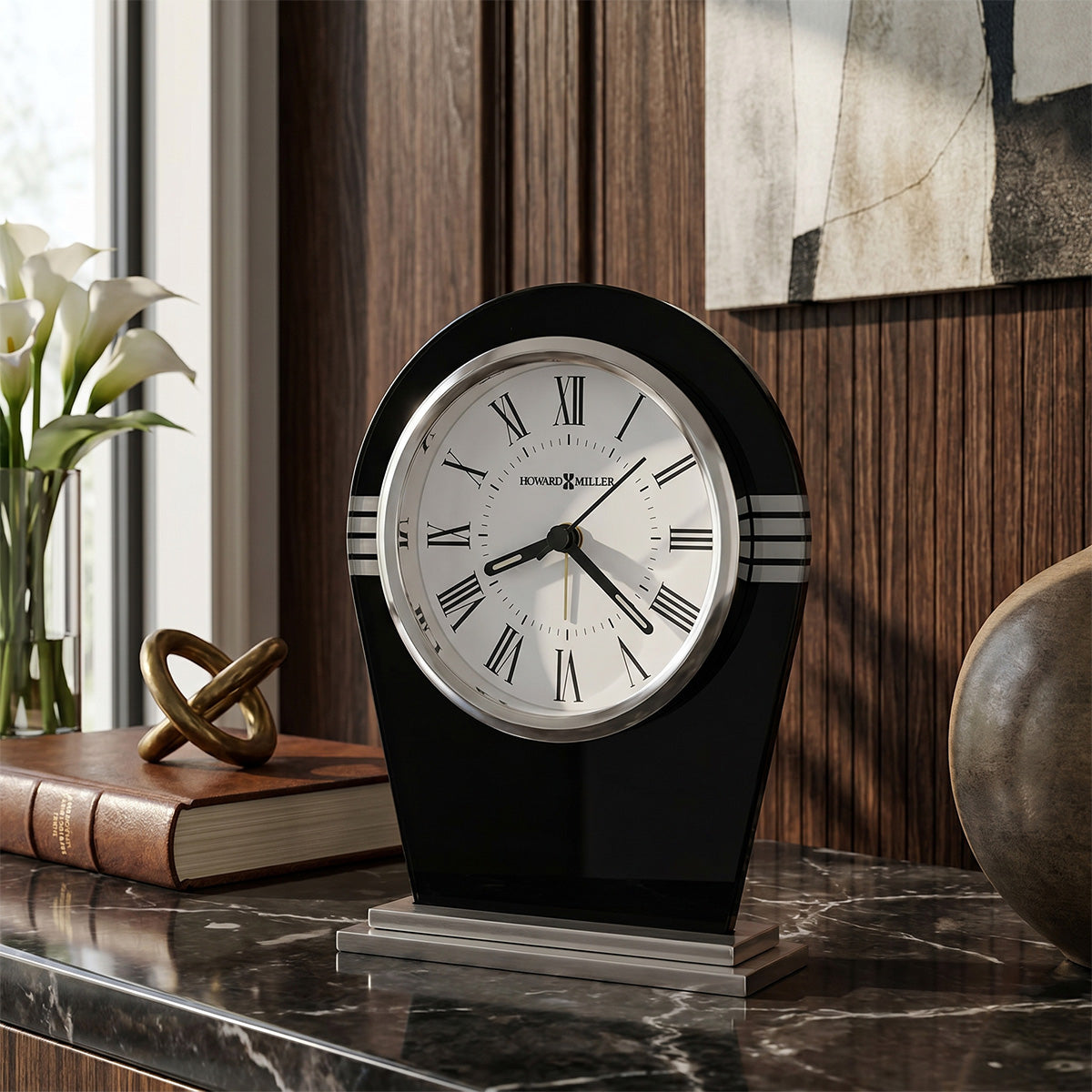 Decorative clock on a marble surface with books and flowers in the background
