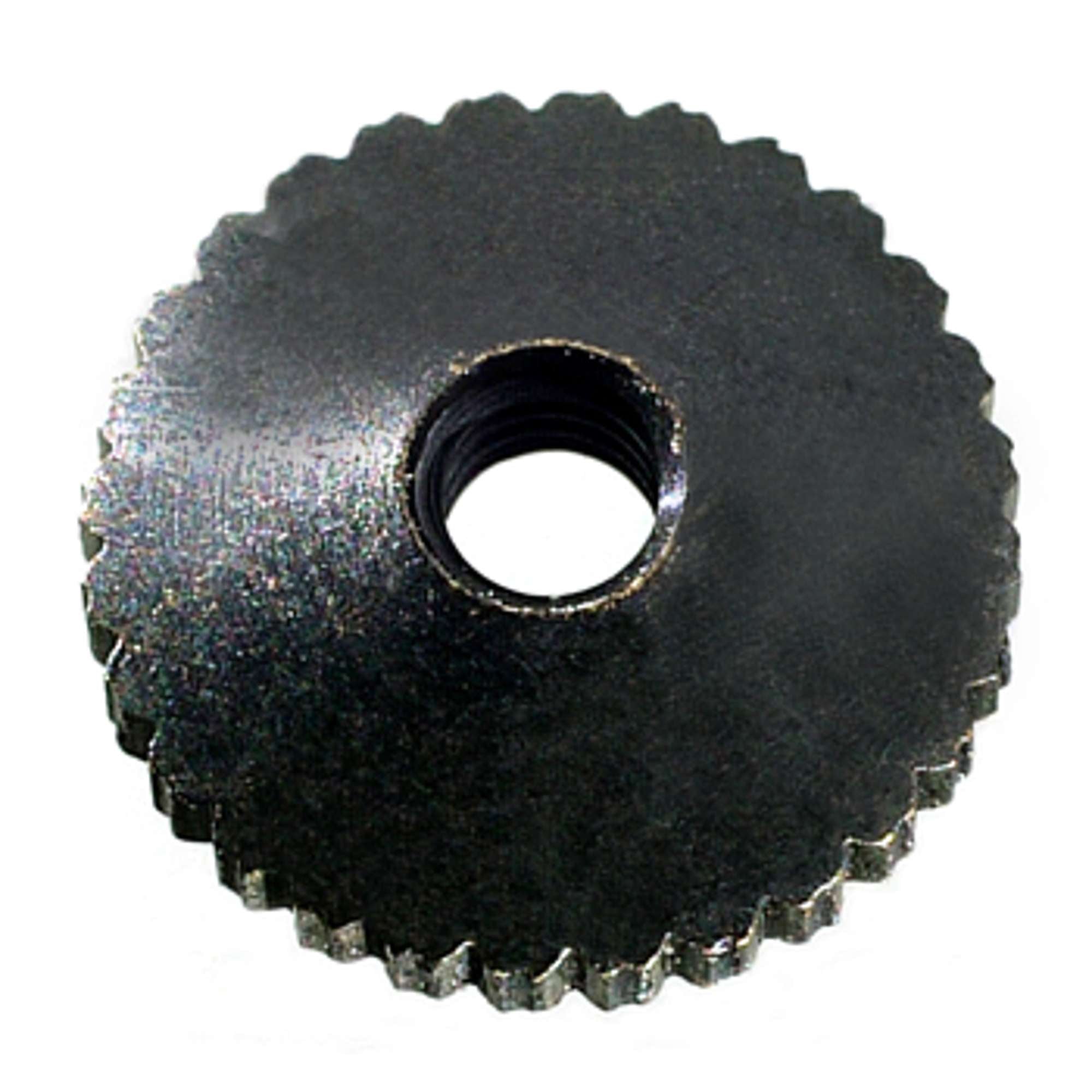 Close-up of a metal gear with a central hole and jagged edges.