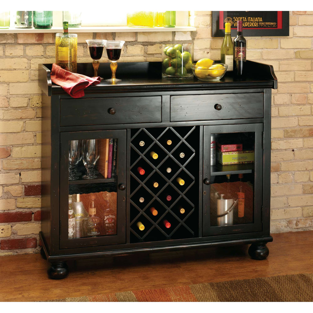 A stylish black wine cabinet with glass doors displaying various bottles and glasses, set against a brick wall.