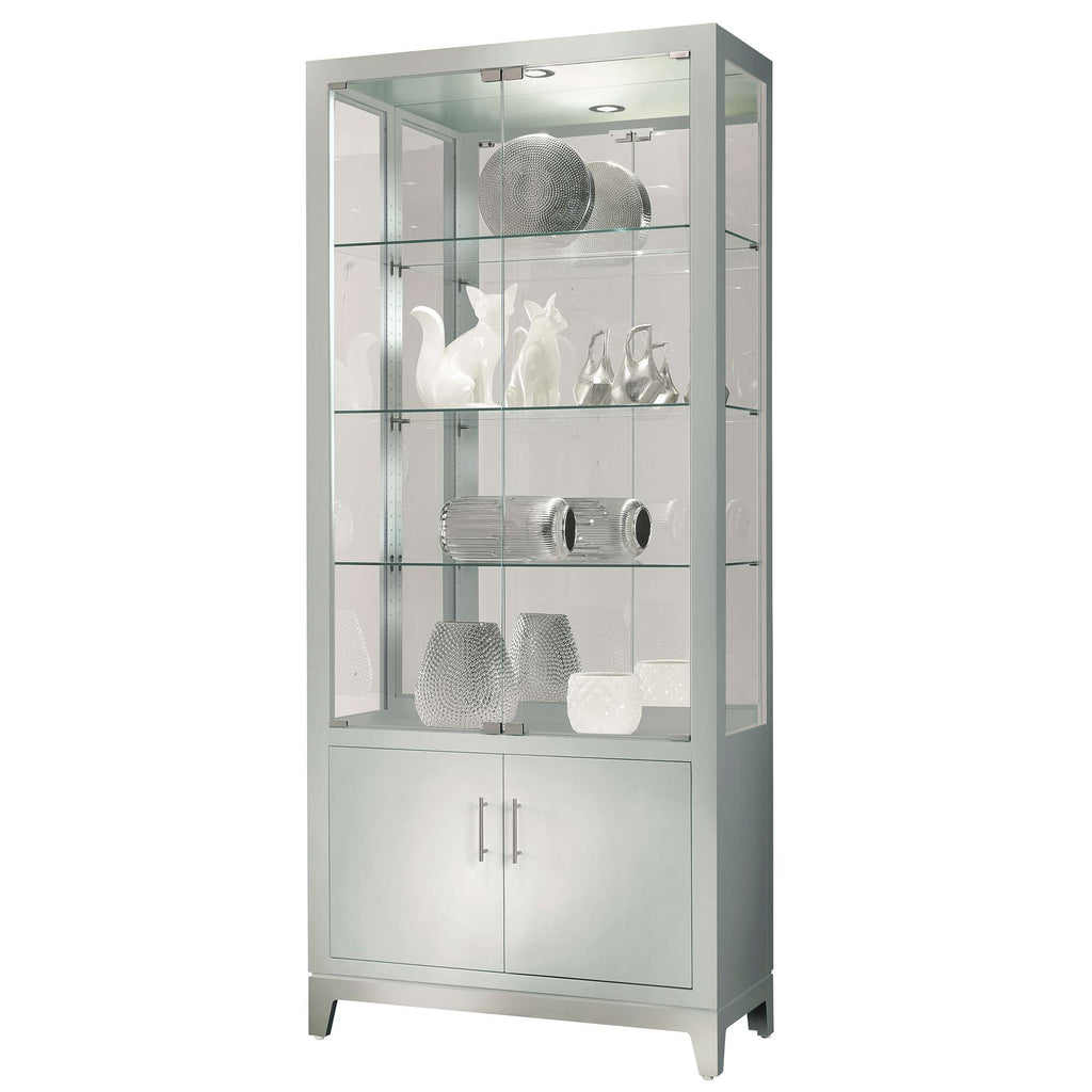 A tall glass display cabinet with illuminated shelves showcasing various decorative items.