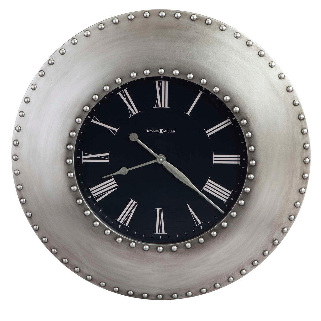 Round wall clock with a black face and Roman numerals, surrounded by a silver studded frame.