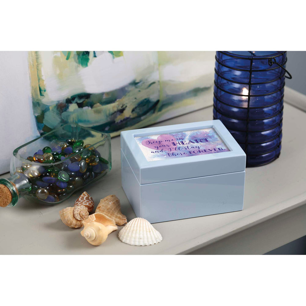 A decorative light blue box on a table surrounded by seashells and decorative items.