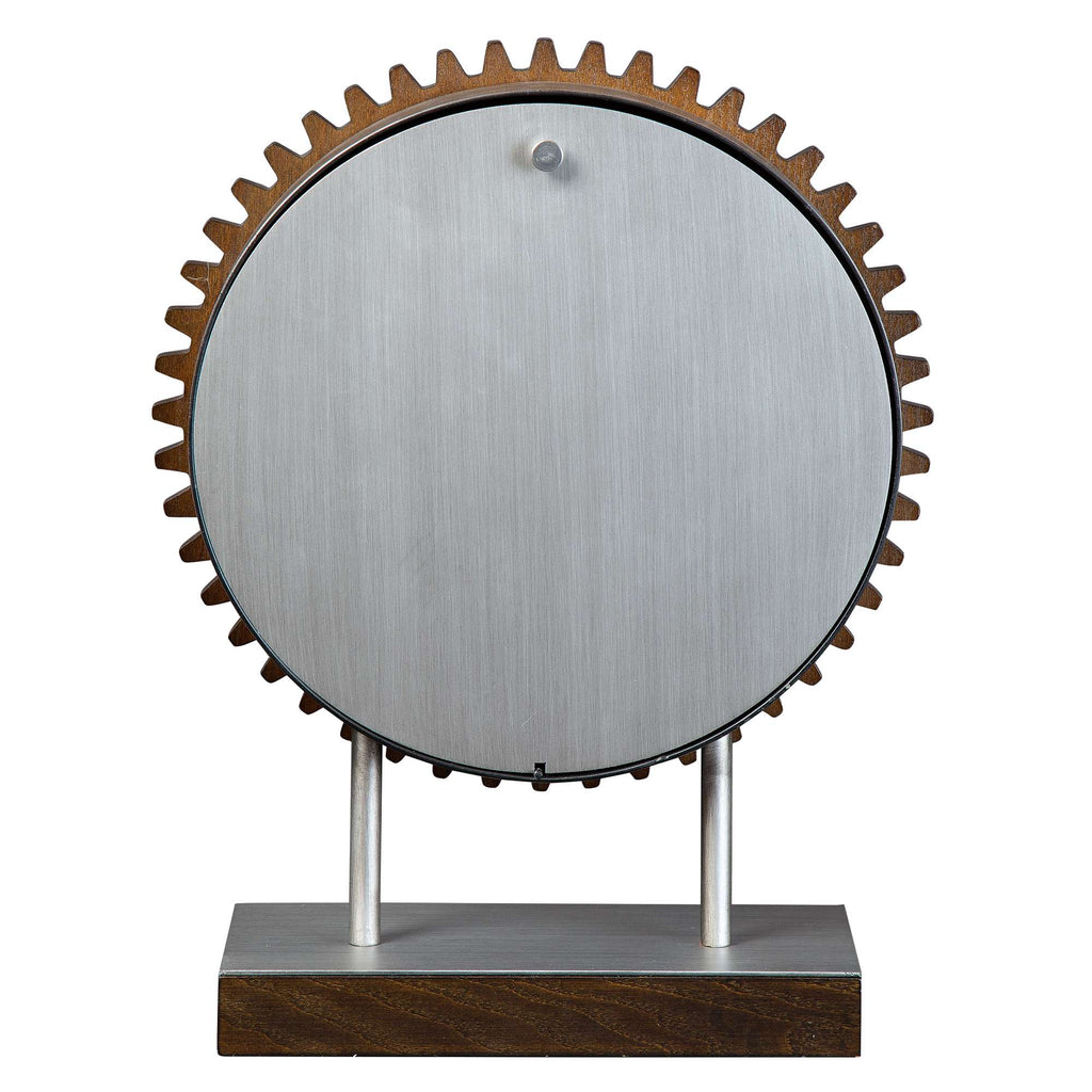 A modern decorative gear sculpture with a metal circular disc and wooden base.