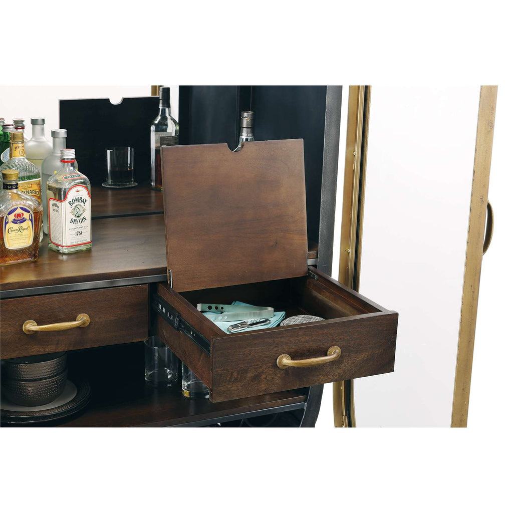 Open drawer on a wooden bar cart displaying bar tools and bottles behind.