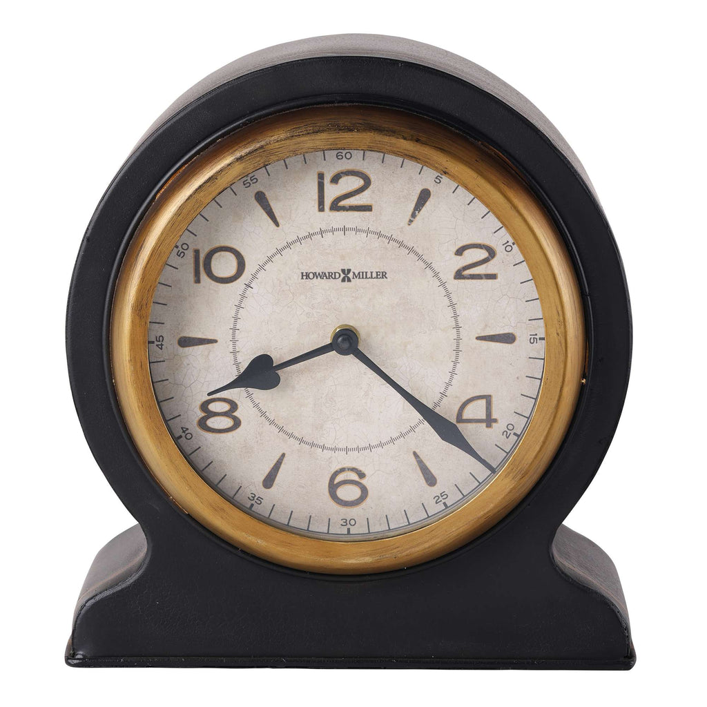 A vintage round alarm clock with black casing and gold accents