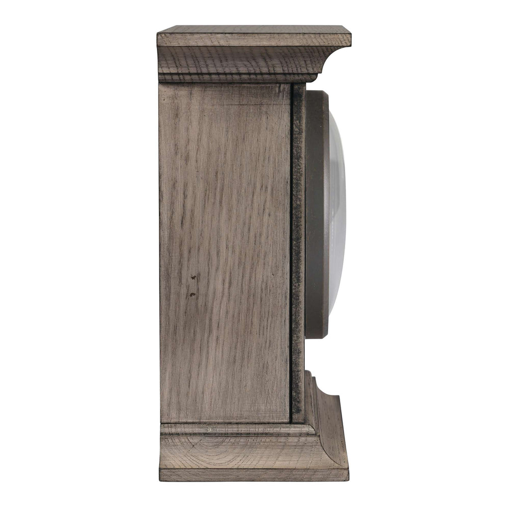 Side view of a round wall clock in a wooden frame.