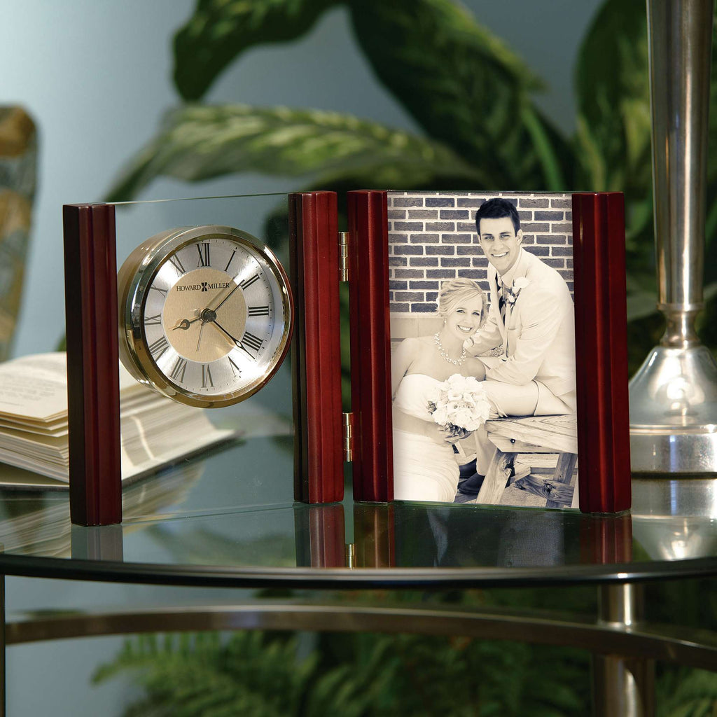 A decorative clock and photo frame displayed on a glass table.