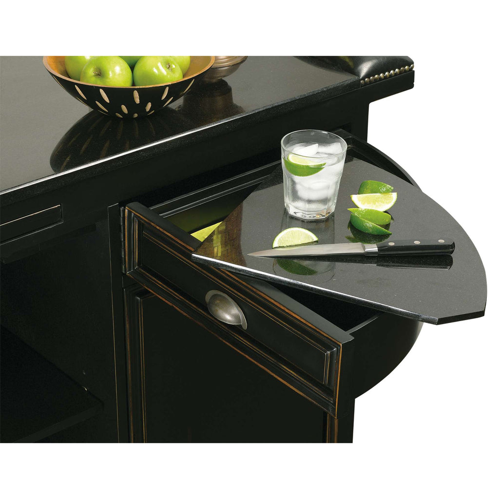 A stylish black kitchen island with a fold-out cutting board, knife, and glass of water with lime slices.