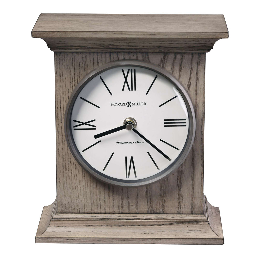 A wooden mantel clock with a round white face and Roman numerals.