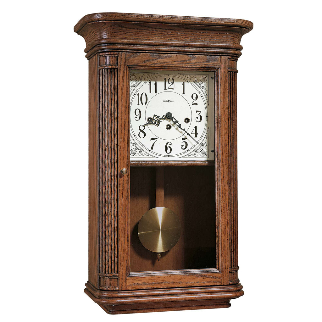A wooden wall clock with a glass front and decorative detailing.