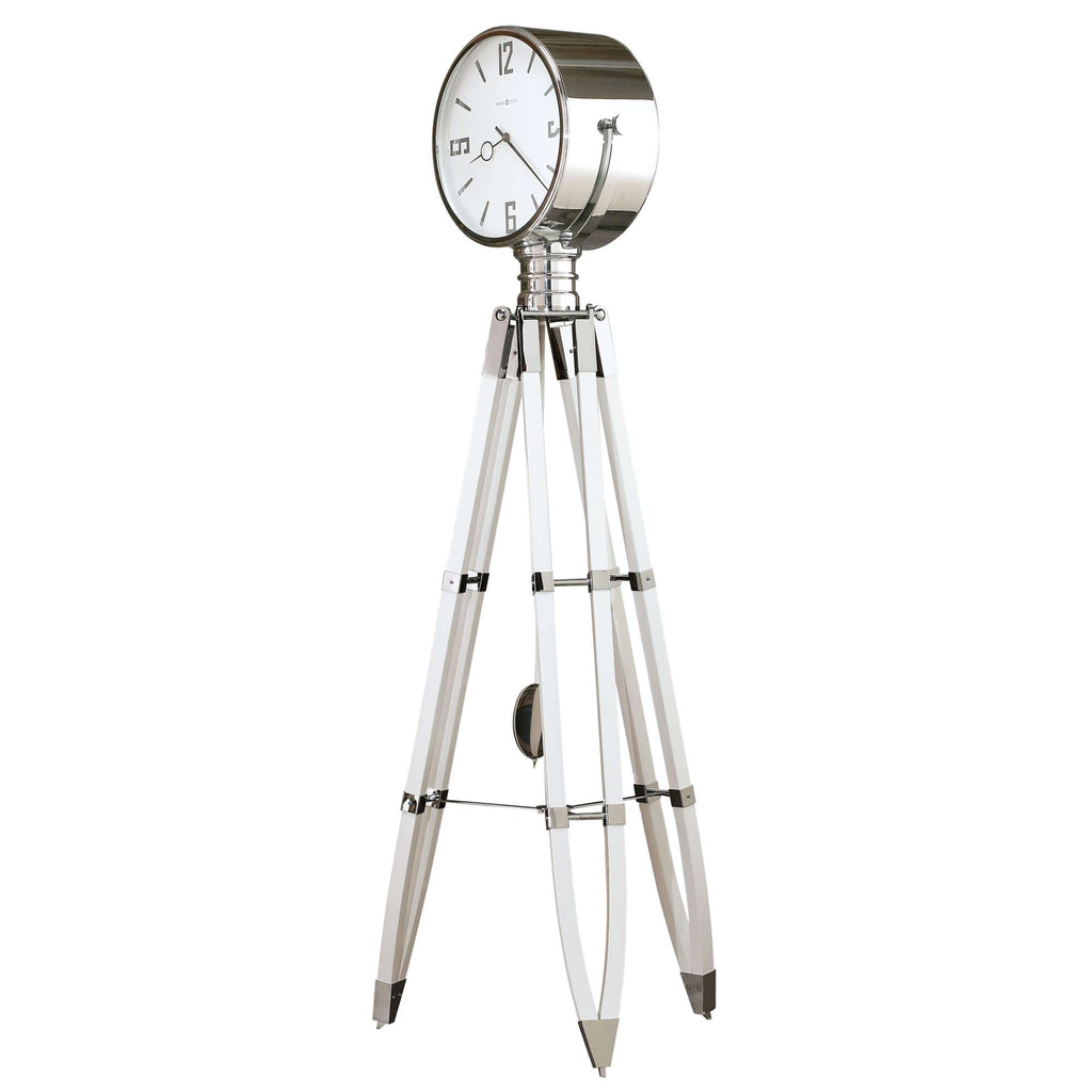 A modern tripod clock with a sleek silver design and clear legs.