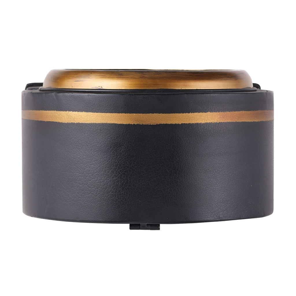 Close-up of a round black and gold dish or container.