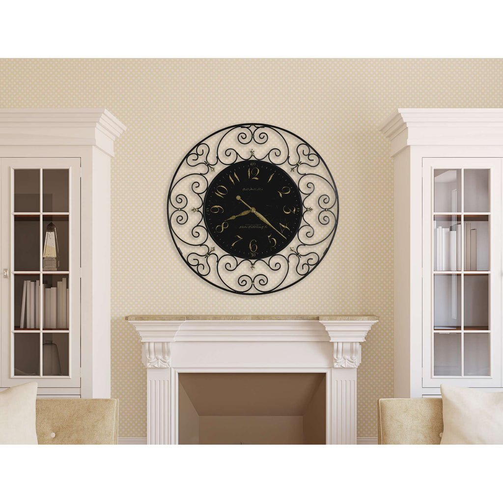 Wall clock with decorative design above a fireplace in a living room.