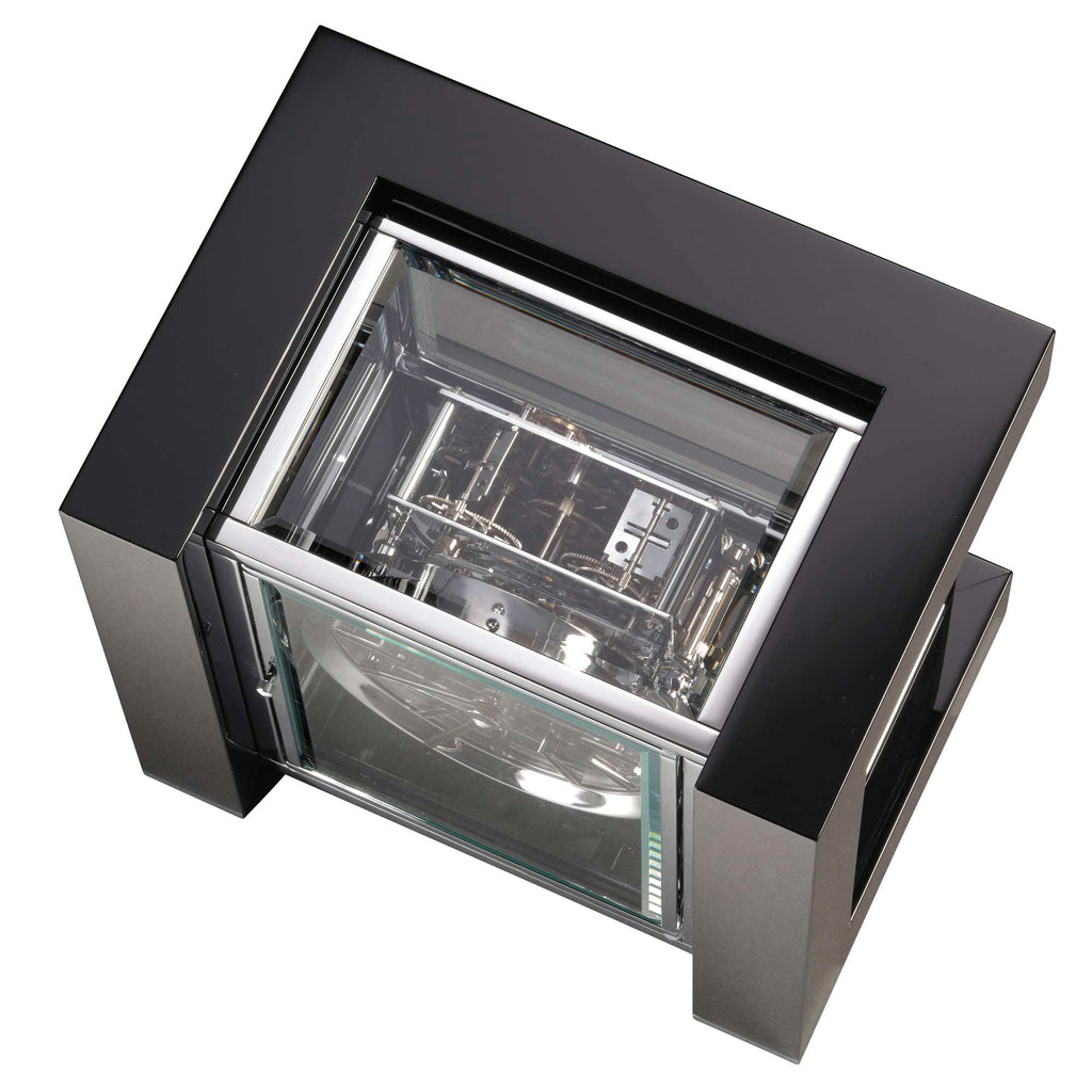 A top view of a modern, minimalist clock with a transparent casing