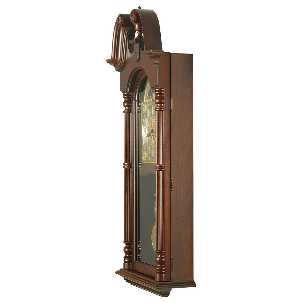 A vintage wooden wall clock with ornate detailing and a glass front.