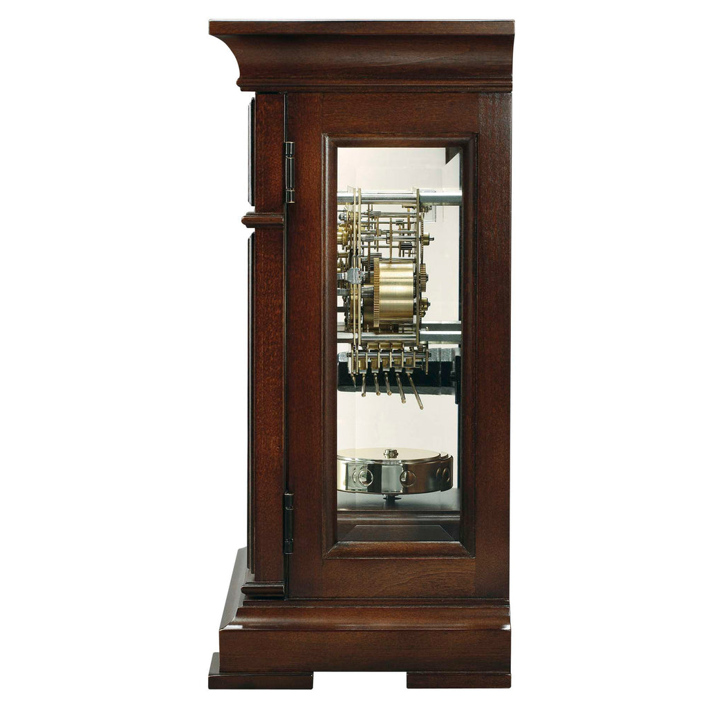 A wooden clock cabinet with a glass front showcasing intricate clock mechanisms.