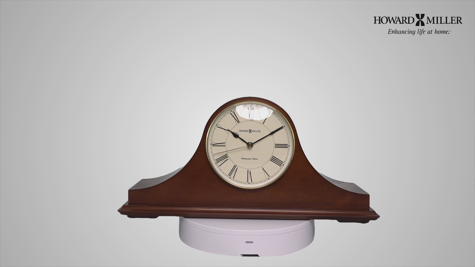A wooden mantel clock with a cream dial and roman numerals, displayed on a white surface.
