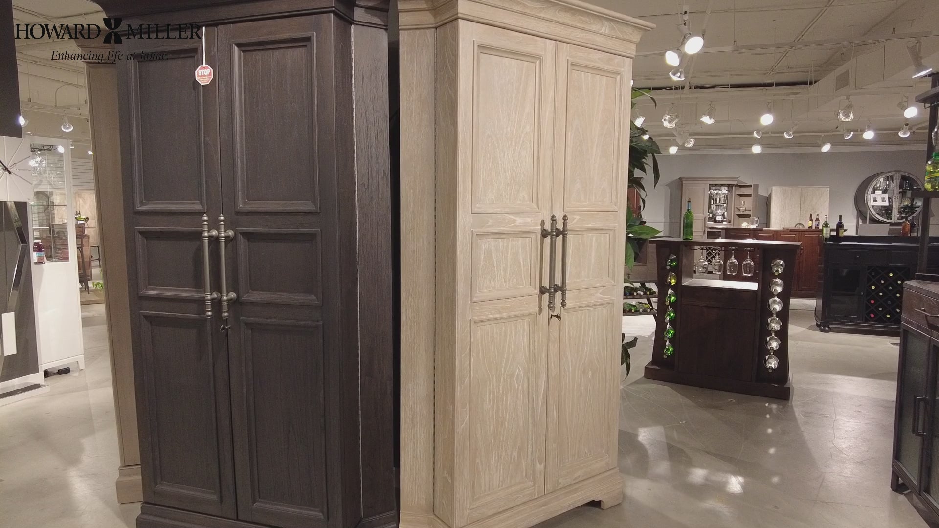 Two tall cabinets in a showroom, one dark and one light wood finish.