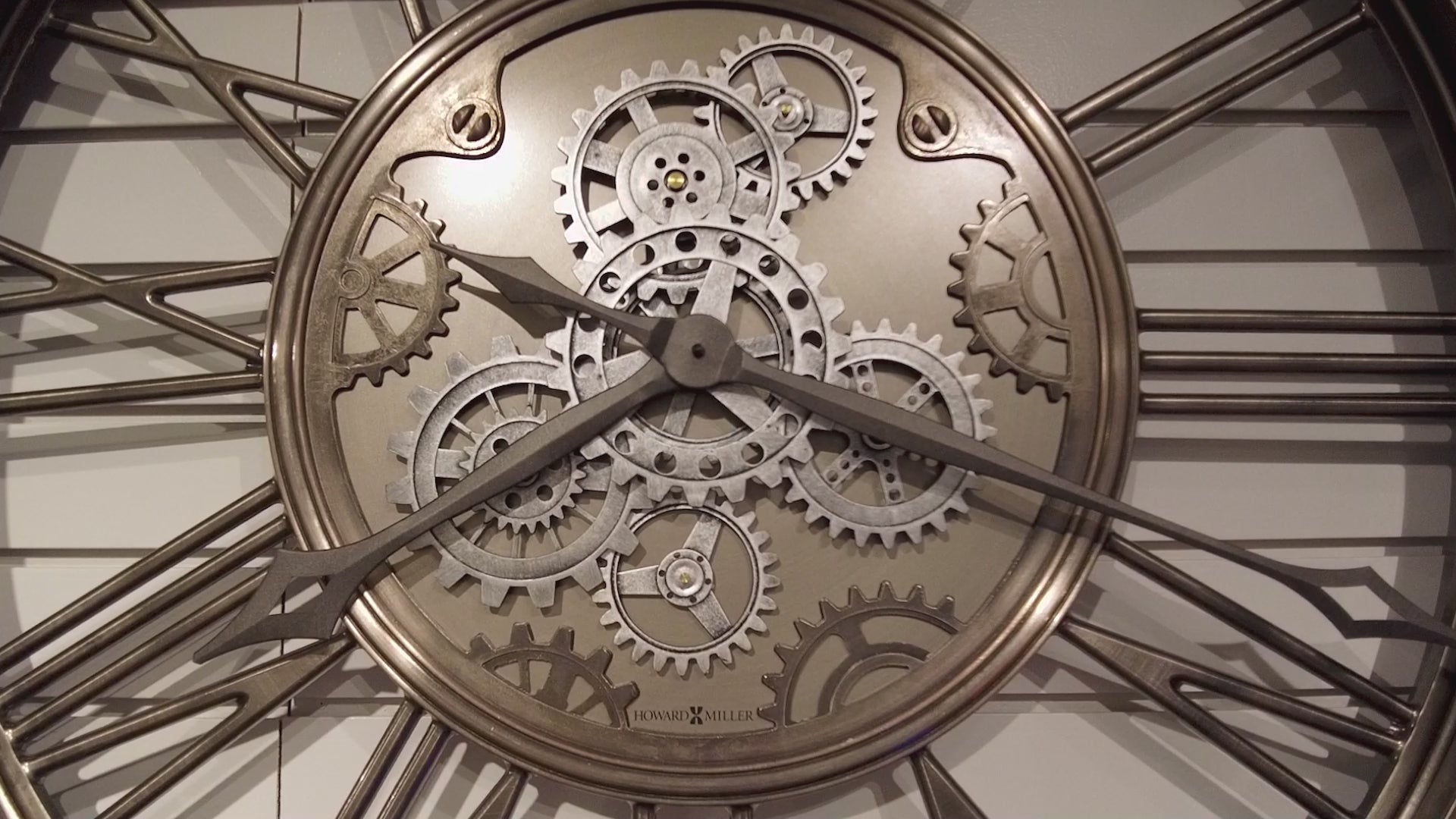 Close-up of a decorative wall clock showcasing intricate gears and hands.