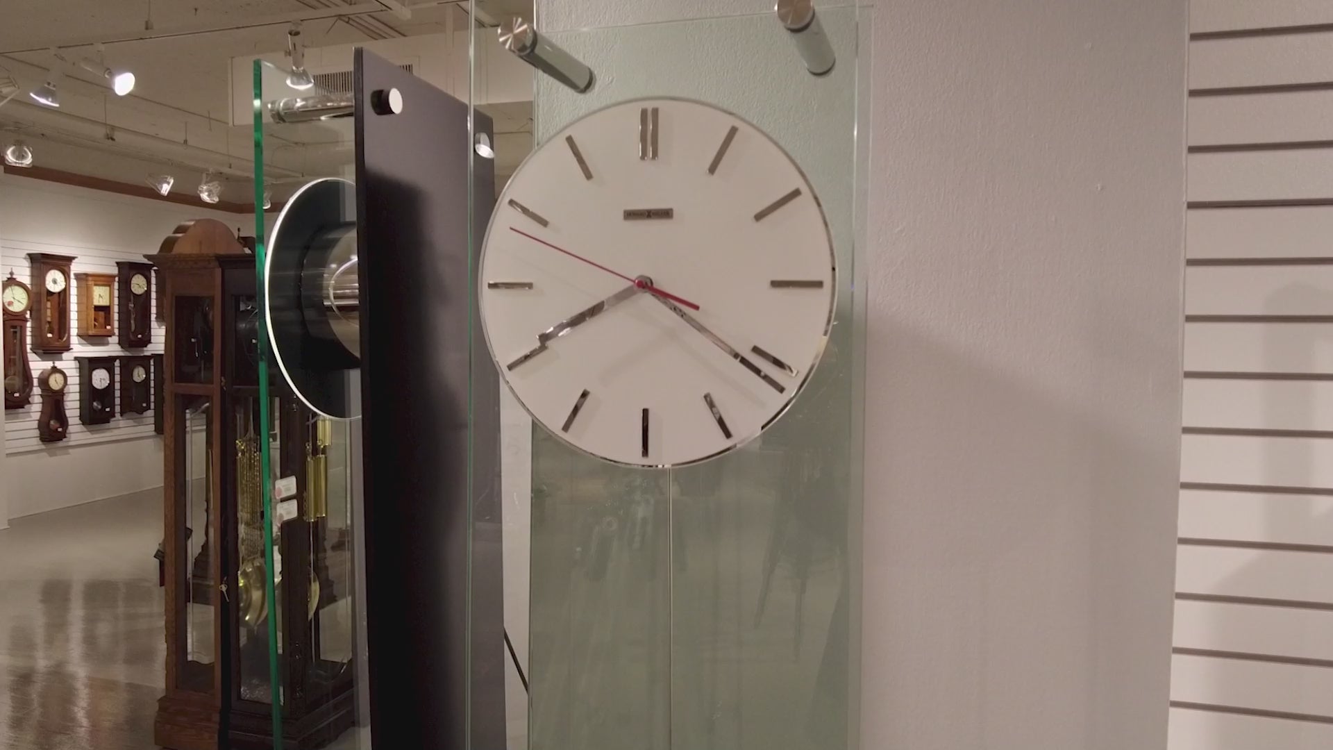 A large wall clock displayed in a gallery, featuring a minimalist design.