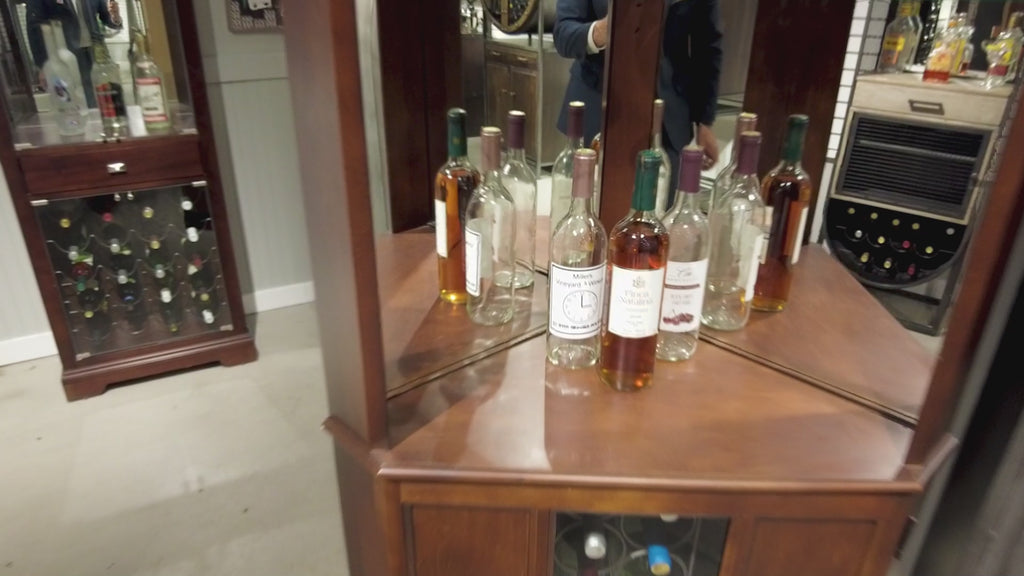 A display of various liquor bottles in a wooden cabinet.