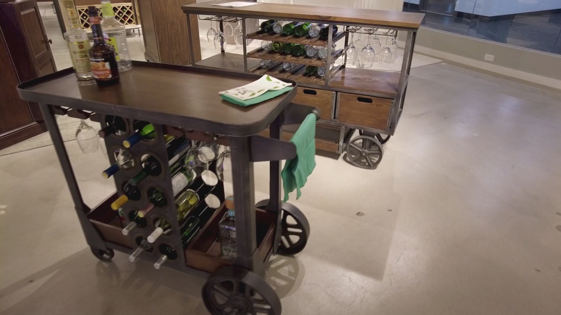 Two wooden serving carts with bottles and glassware in a modern interior
