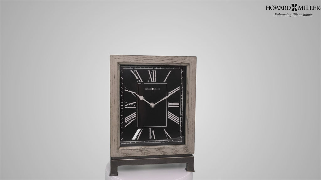 A decorative table clock with a black face and silver accents.