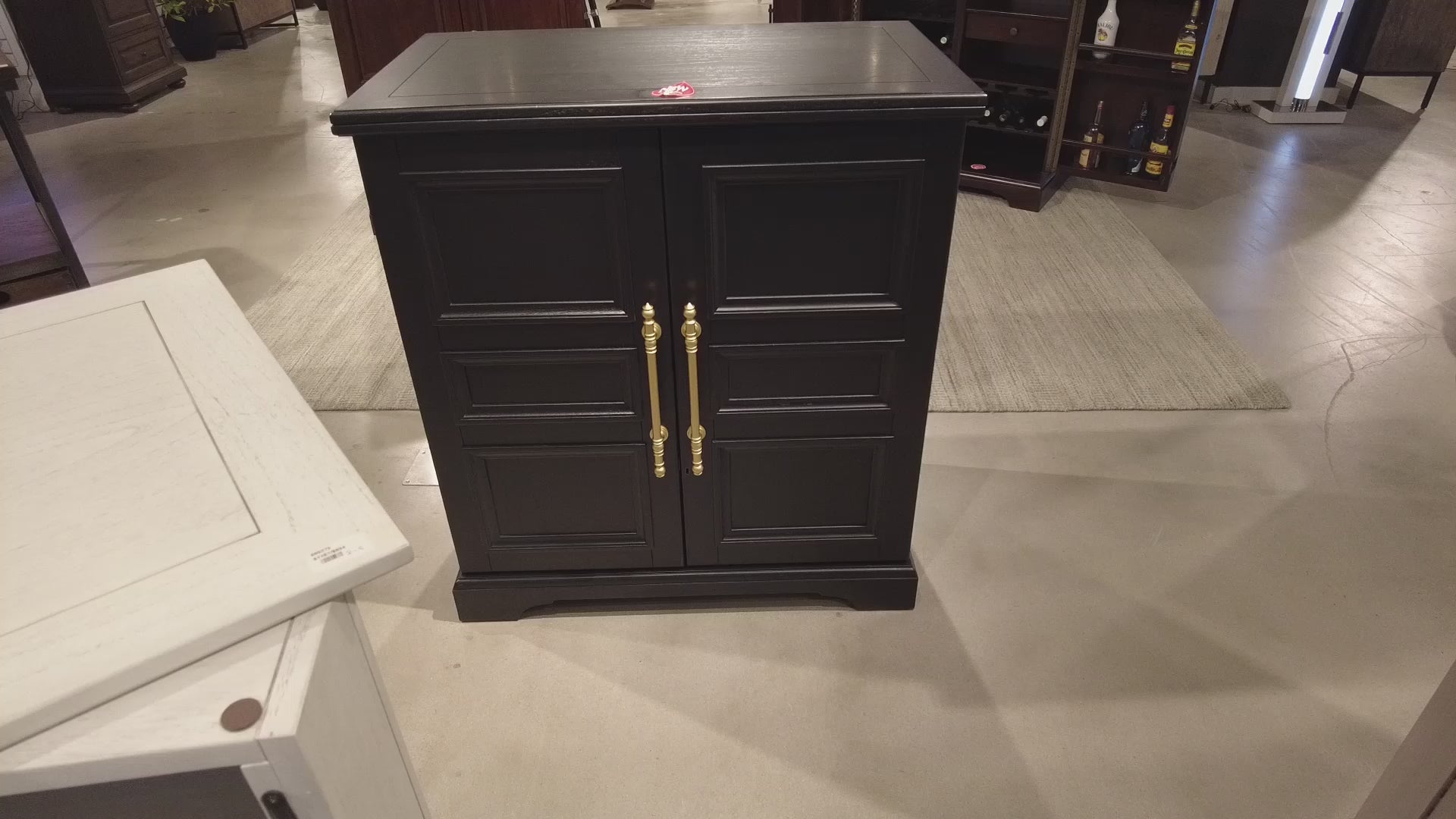 Black wooden cabinet with gold handles in a furniture store