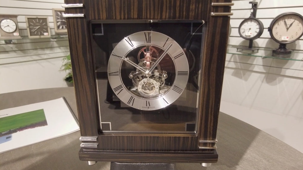 Close-up of a decorative mechanical clock with an exposed movement and a dark wood finish.