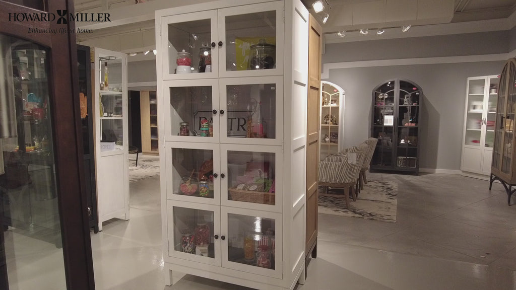 A white cabinet with glass doors displaying various items inside, set in a modern interior.