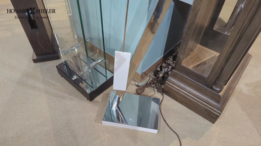 A close-up view of a modern lamp base with a mirrored surface, surrounded by glass and wooden furniture.