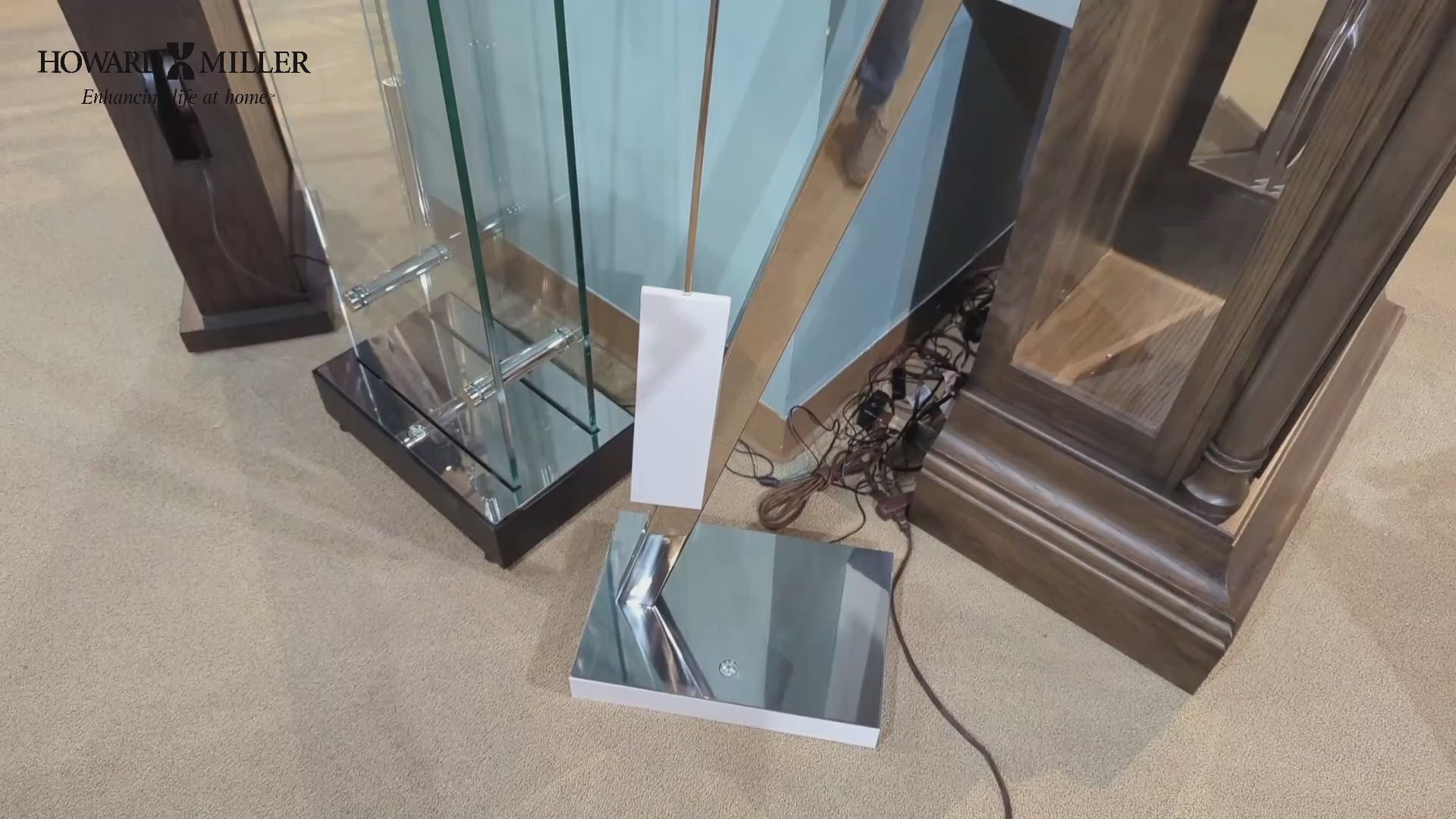 A close-up view of a modern lamp base with a mirrored surface, surrounded by glass and wooden furniture.