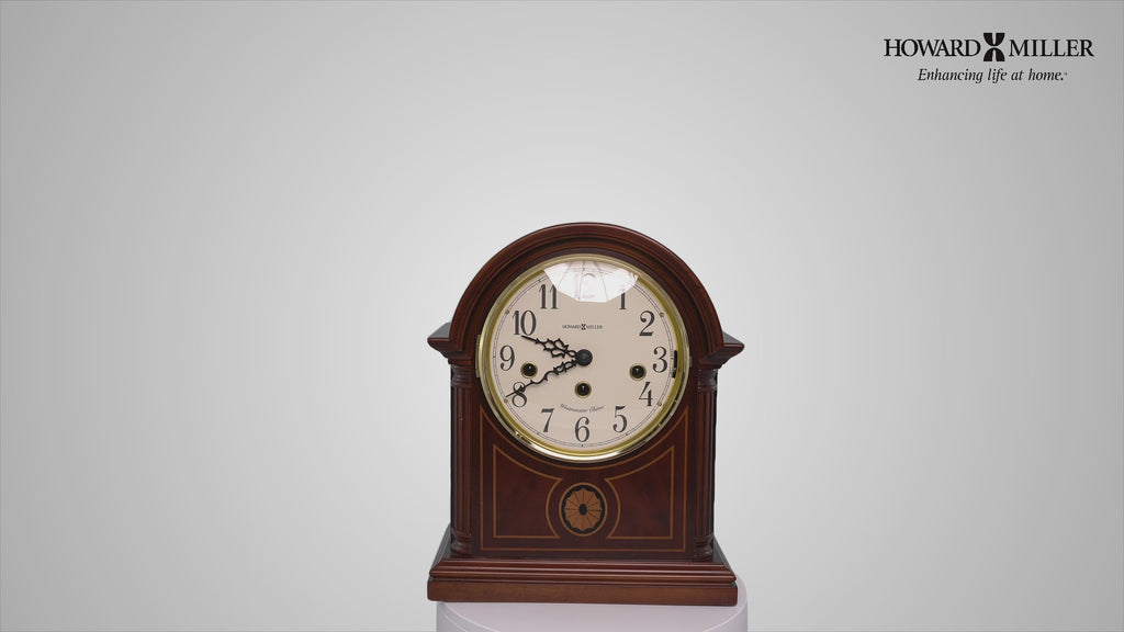A vintage mantel clock with an arched top and decorative detailing.