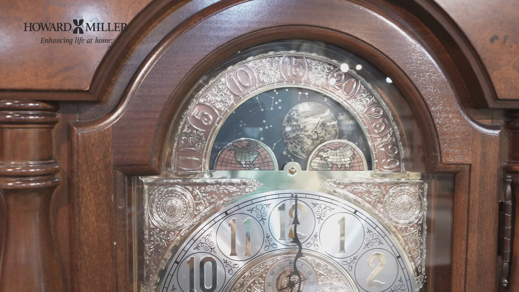 Close-up of an ornate grandfather clock face with decorative elements.