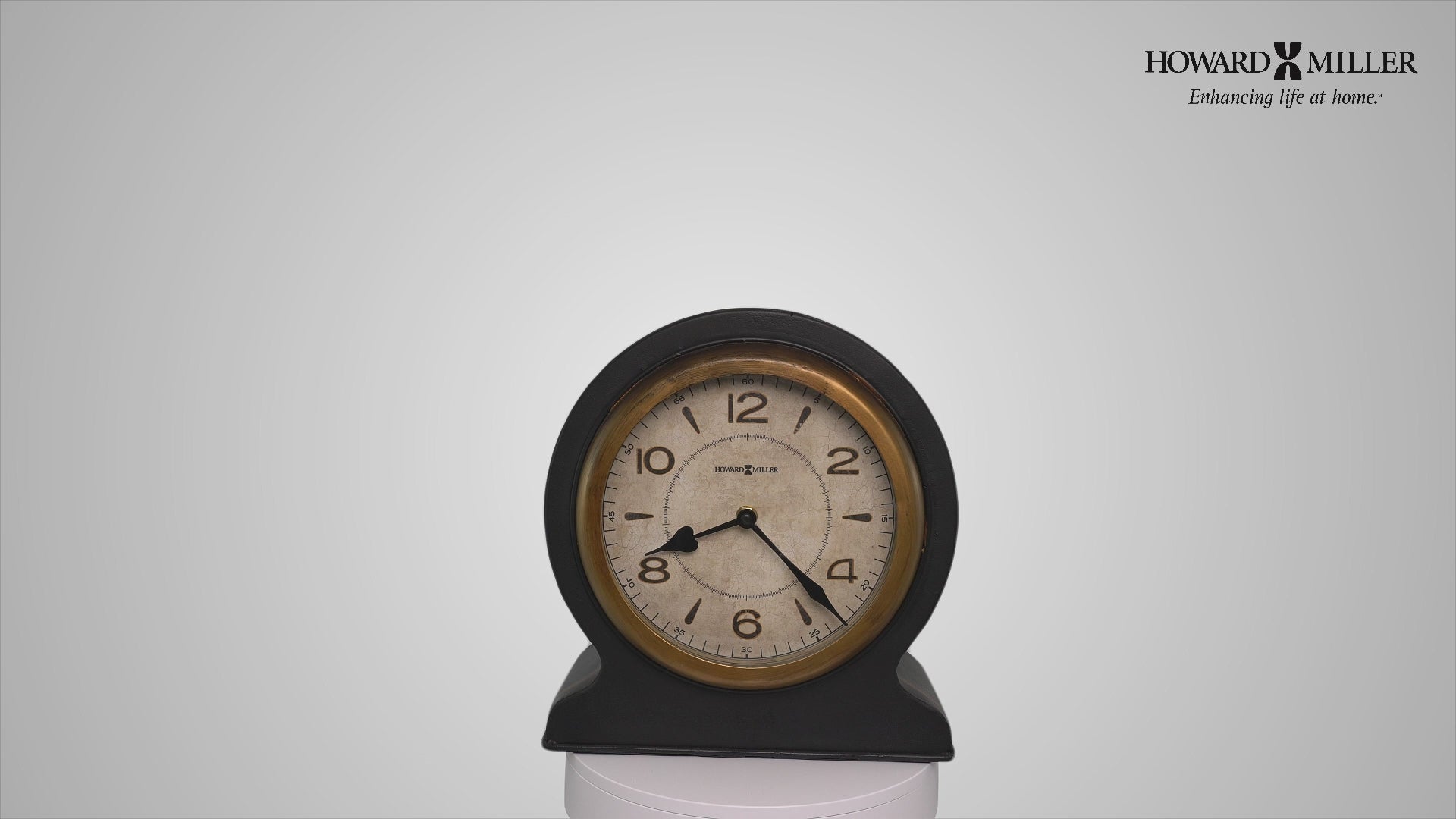 A vintage round alarm clock with a beige face and black casing.
