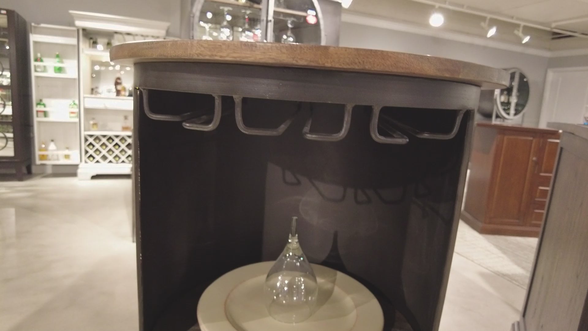 Close-up view of a wooden table with hooks and a glass vase on a circular surface.