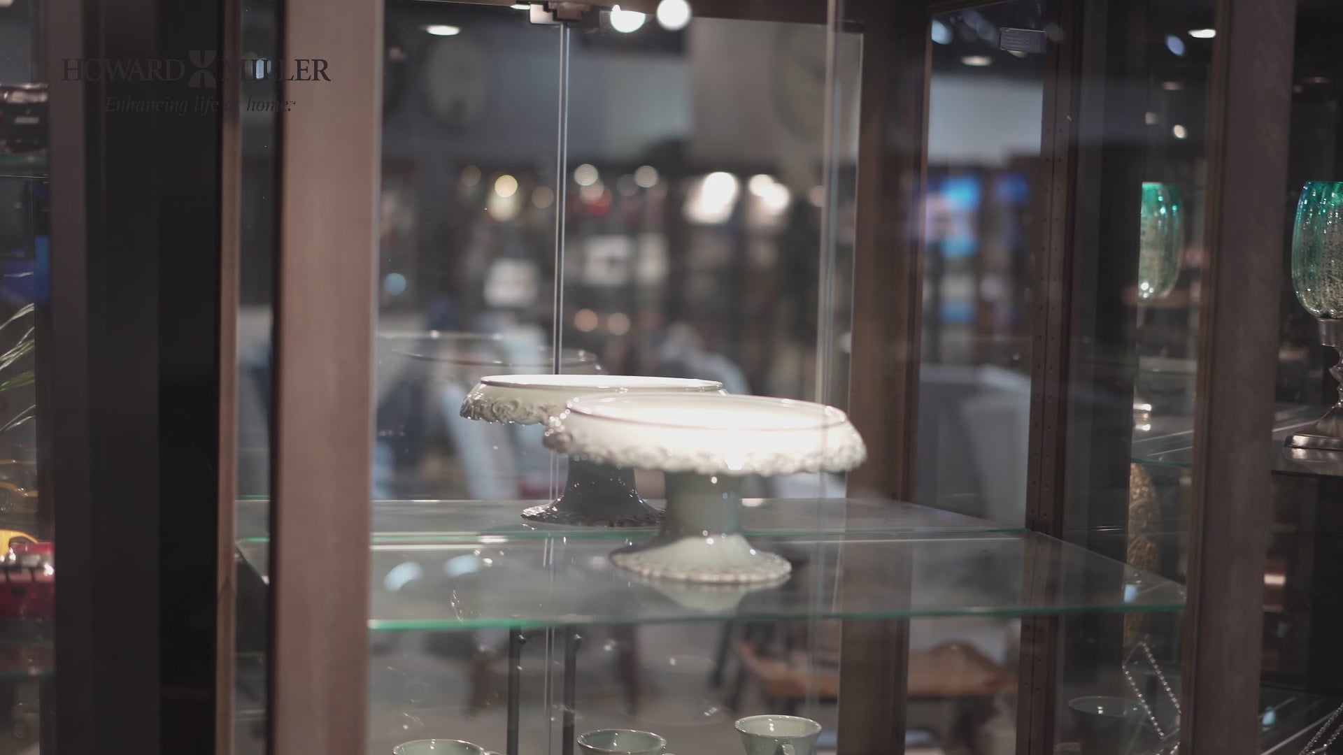 A decorative cake stand displayed in a glass cabinet