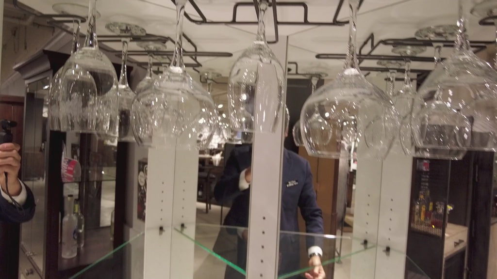 Reflection of glassware and a person in a display.