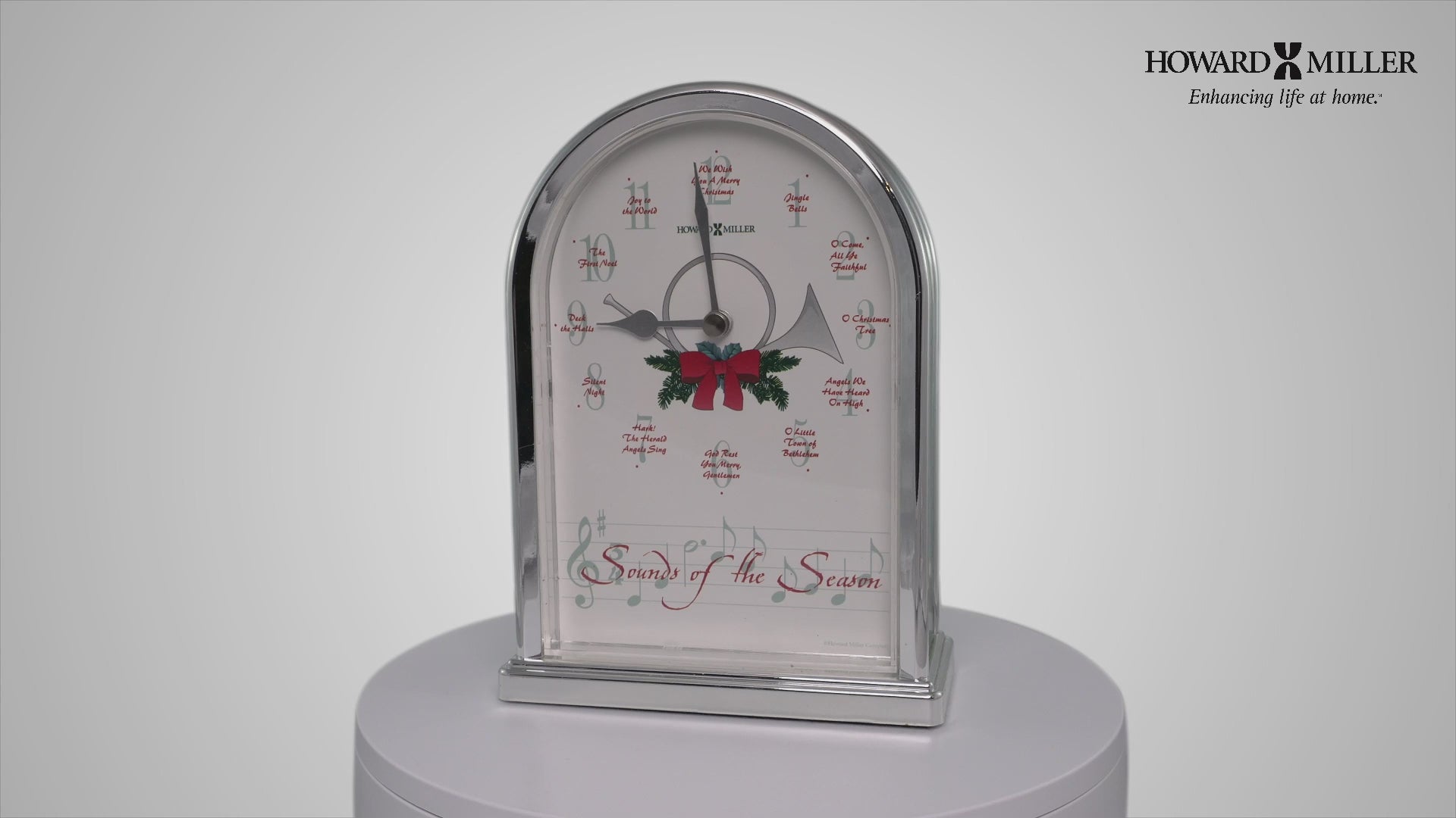 Decorative clock with a holiday theme featuring holly and a festive design.