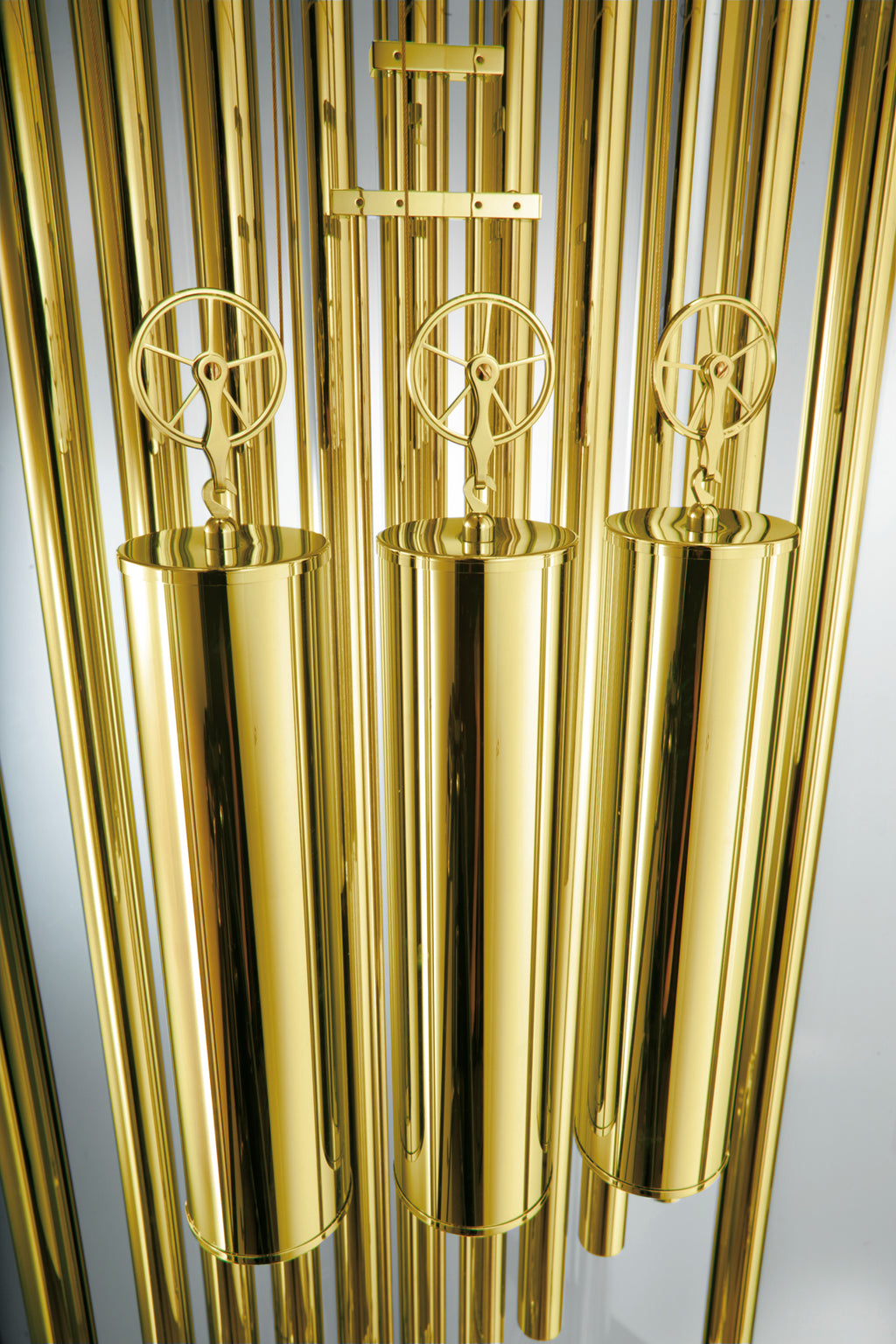 Close-up of metallic gold tubes with circular mechanisms