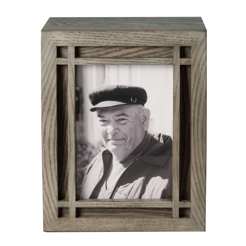 Black and white photo of an older man wearing a cap, displayed in a wooden frame.