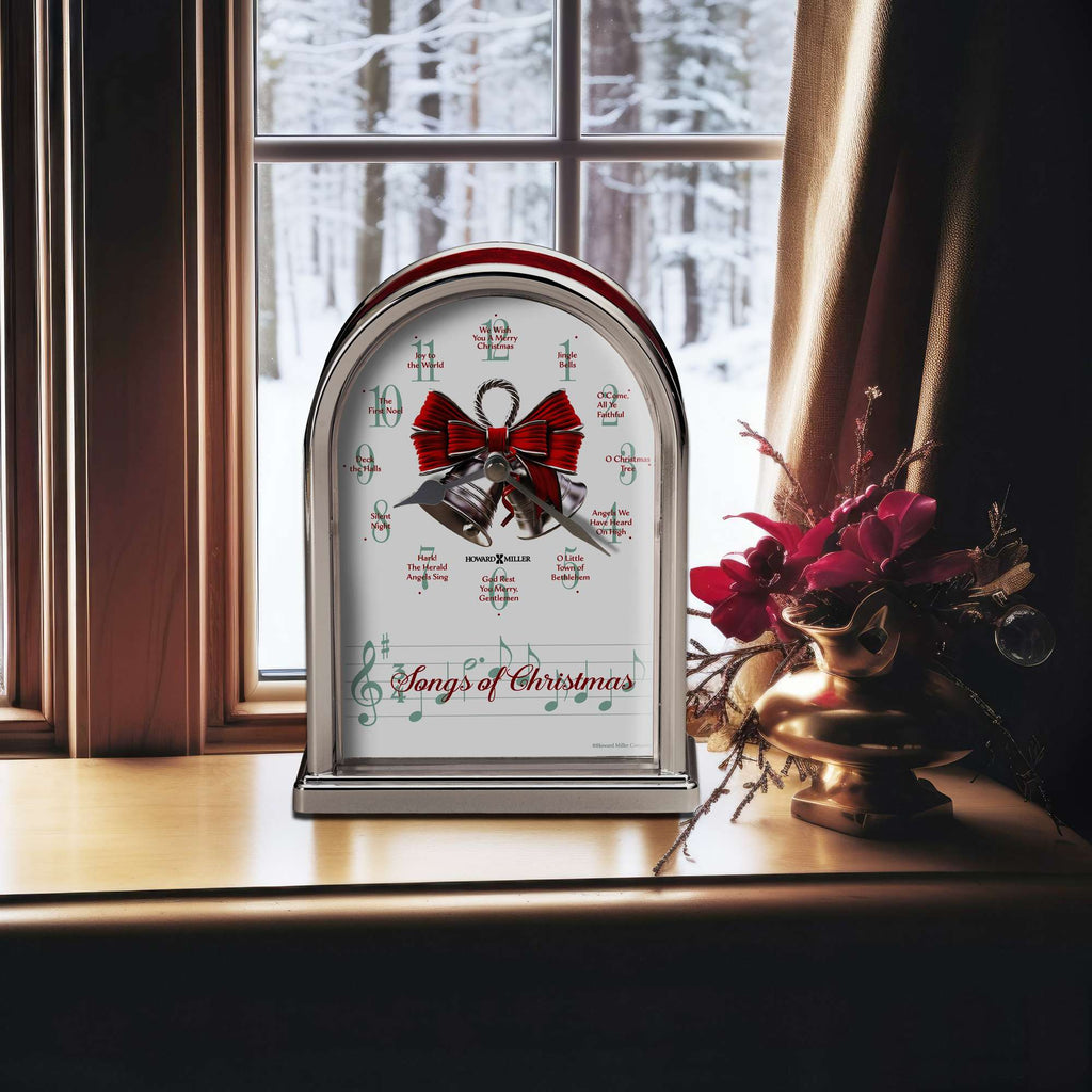 A decorative clock with a red bow and the text 'Songs of Christmas' on a windowsill with snowy scenery outside.